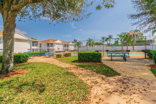 view of home's community with tennis court