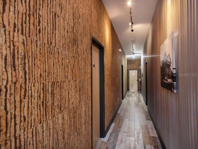 hallway featuring a towering ceiling and light hardwood / wood-style floors