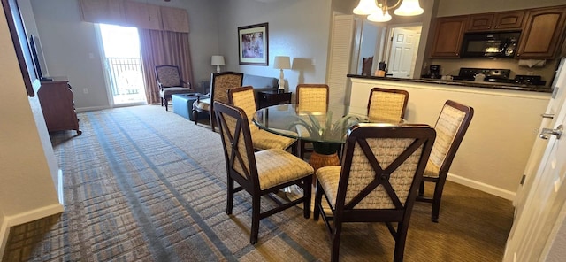 carpeted dining room with a chandelier