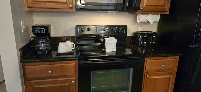 kitchen featuring dark stone countertops and black appliances