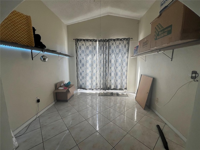 unfurnished dining area with a textured ceiling, light tile flooring, and vaulted ceiling