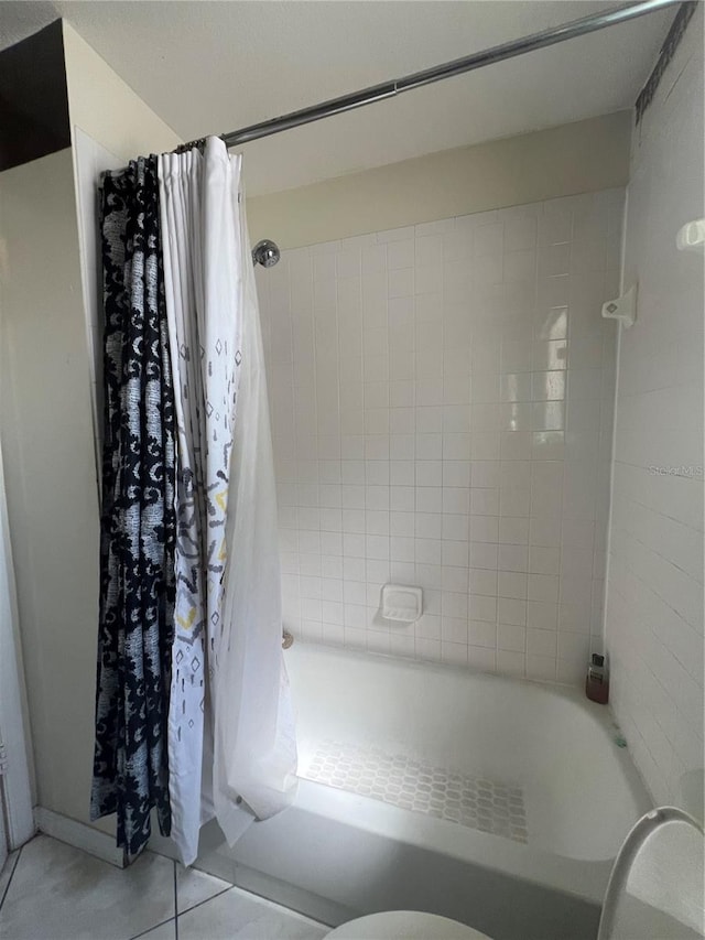 bathroom with shower / tub combo with curtain and tile flooring