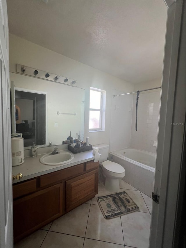 full bathroom featuring tiled shower / bath, toilet, tile flooring, and oversized vanity