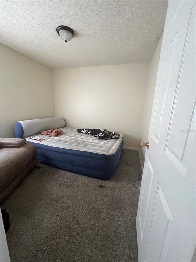 bedroom with a textured ceiling and carpet