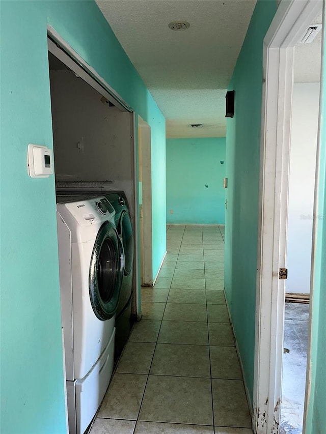 laundry room featuring independent washer and dryer and light tile floors