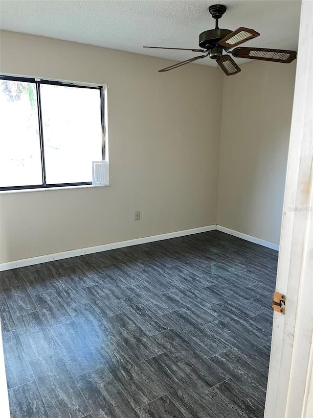 empty room featuring ceiling fan, a textured ceiling, and dark hardwood / wood-style flooring