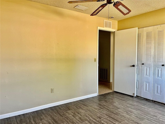 unfurnished bedroom featuring dark wood-style flooring, visible vents, and baseboards