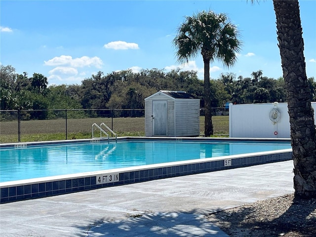 community pool with a shed, fence, and an outdoor structure