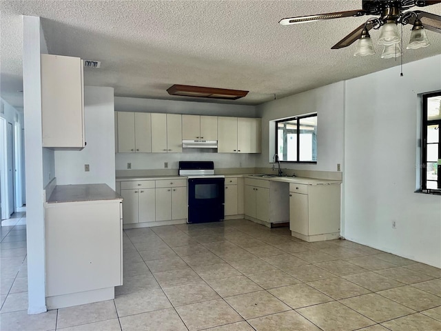 kitchen featuring visible vents, electric stove, light countertops, under cabinet range hood, and a sink