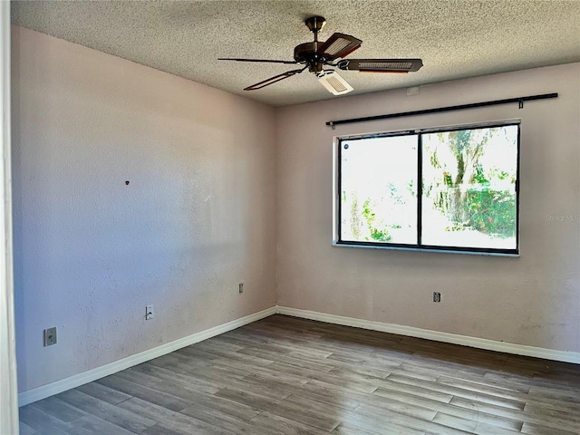 empty room featuring a ceiling fan, a textured ceiling, baseboards, and wood finished floors