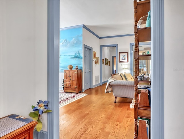 interior space with crown molding and light hardwood / wood-style flooring