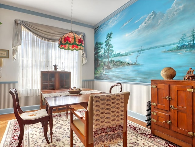 dining space featuring crown molding and light hardwood / wood-style flooring