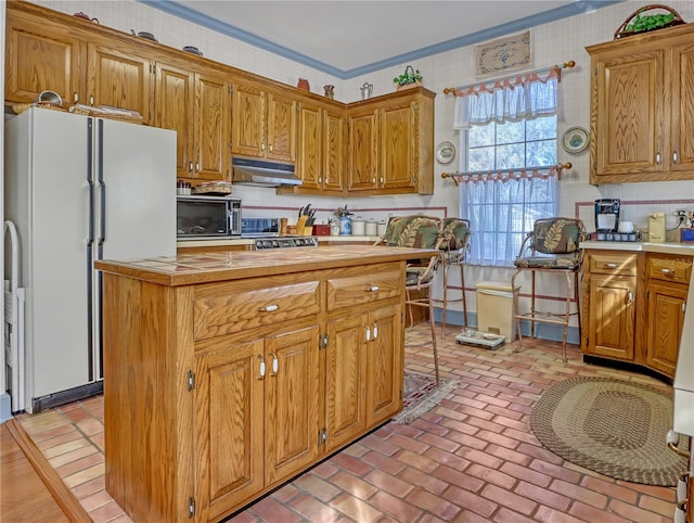 kitchen with ornamental molding and white fridge