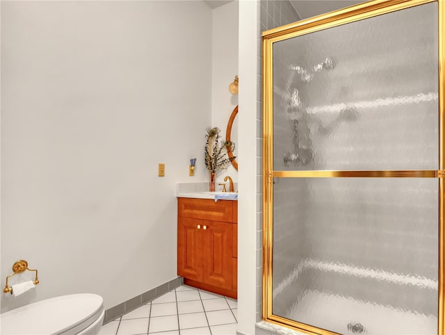 bathroom featuring toilet, tile floors, a shower with shower door, and vanity