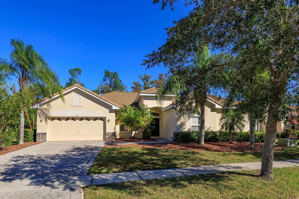 ranch-style house featuring a garage and a front yard