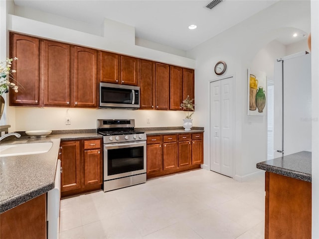 kitchen featuring appliances with stainless steel finishes, sink, and light tile floors