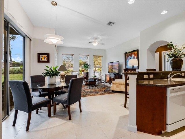 dining area with sink, ceiling fan, and light tile flooring