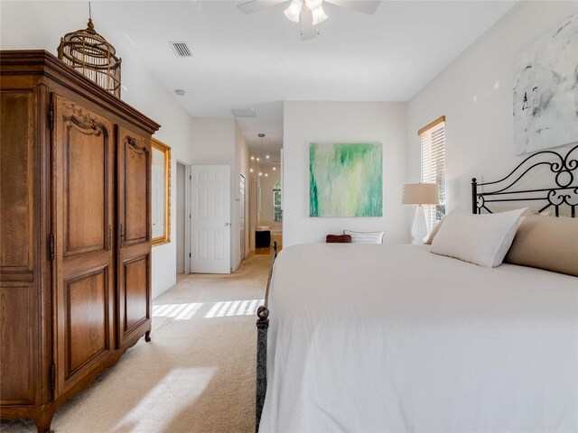 carpeted bedroom with ceiling fan and ensuite bath