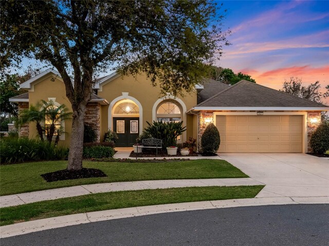 view of front of property with a garage and a lawn