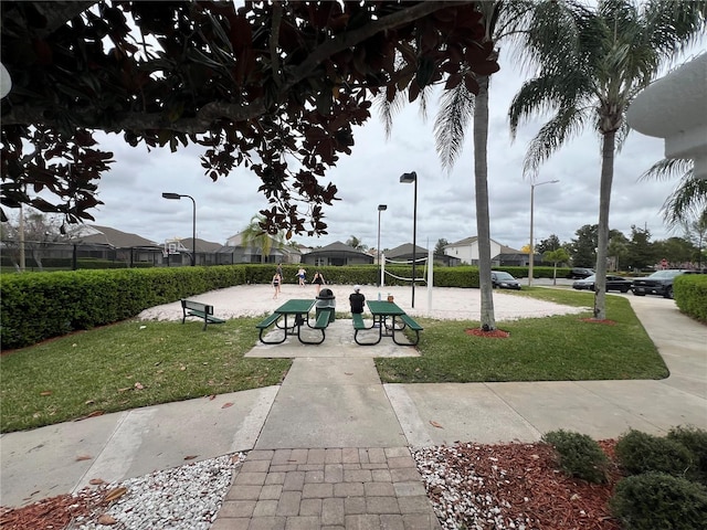 view of property's community featuring a lawn and volleyball court