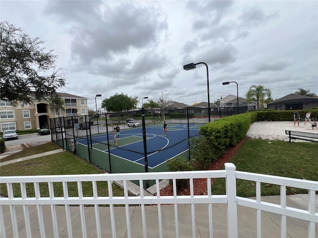 view of sport court featuring a lawn