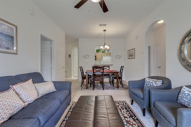 living room with light carpet and ceiling fan with notable chandelier