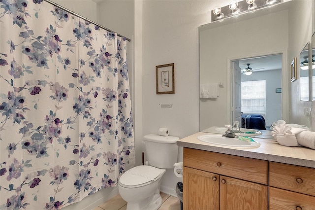 bathroom with toilet, large vanity, ceiling fan, and tile flooring