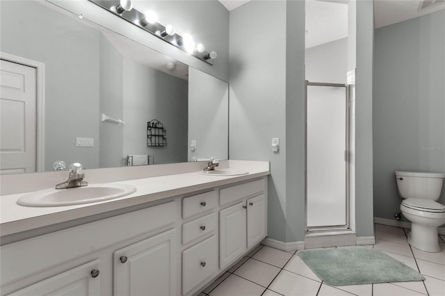 bathroom featuring tile patterned flooring, vanity, a shower with shower door, and toilet