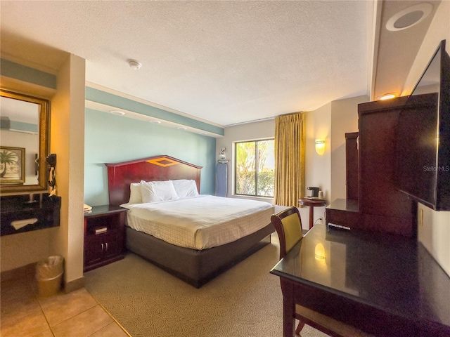 bedroom featuring a textured ceiling and light tile flooring