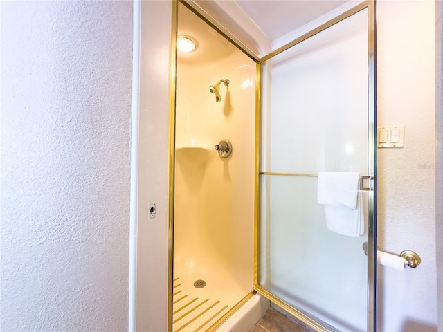 bathroom with walk in shower and tile flooring