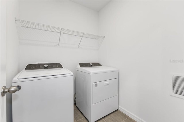 laundry room with light tile patterned floors and washing machine and dryer