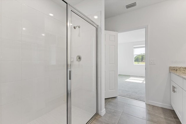 bathroom with tile patterned floors, vanity, and a shower with shower door