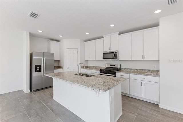 kitchen with an island with sink, sink, white cabinets, and stainless steel appliances