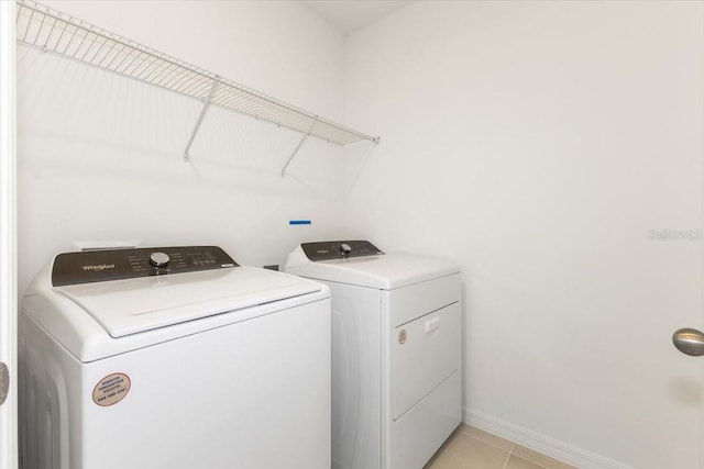 washroom with washer and dryer and light tile floors