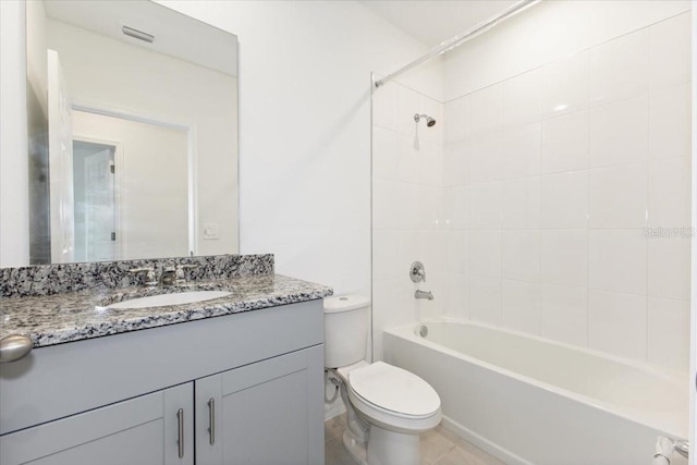 full bathroom with tiled shower / bath, toilet, oversized vanity, and tile flooring