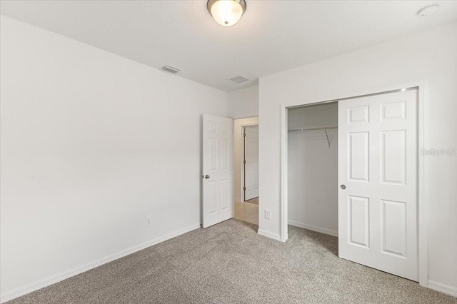 unfurnished bedroom featuring light carpet and a closet