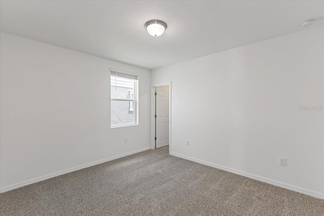 unfurnished room with a textured ceiling and carpet