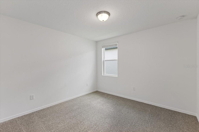 unfurnished room featuring carpet and a textured ceiling