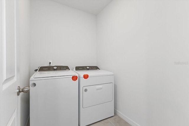 washroom with light tile patterned flooring and washer and dryer