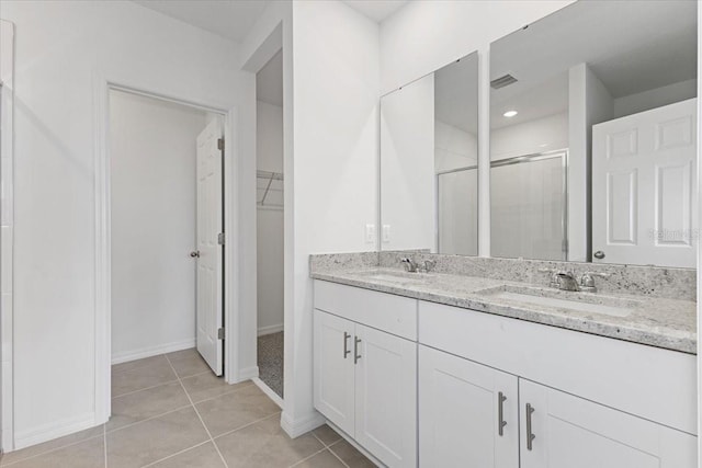 bathroom featuring tile patterned flooring, vanity, and a shower with door