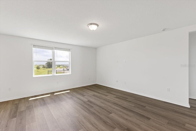 unfurnished room with dark hardwood / wood-style flooring