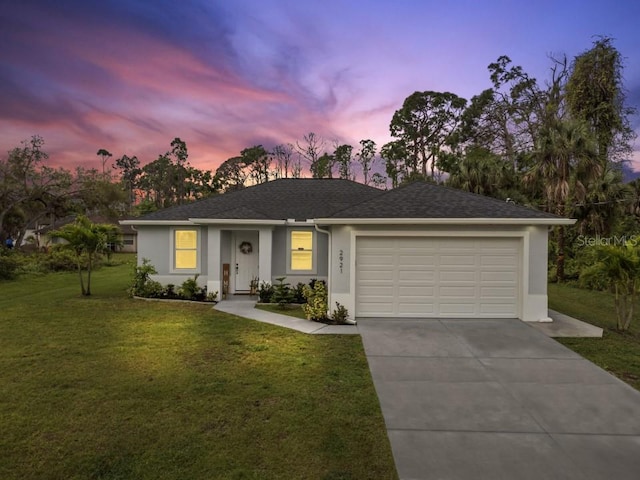 single story home with a lawn and a garage