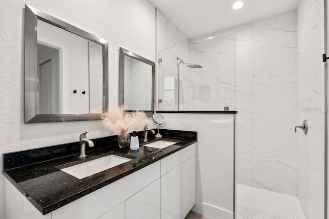 bathroom featuring double sink, a tile shower, and oversized vanity