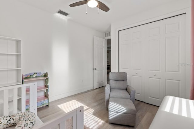 bedroom with a closet, ceiling fan, and light wood-type flooring