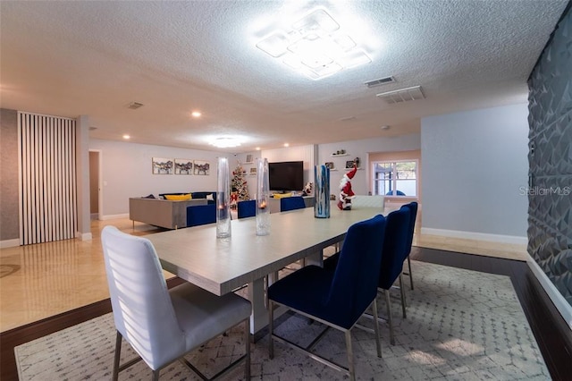 dining space featuring a textured ceiling and light tile patterned floors