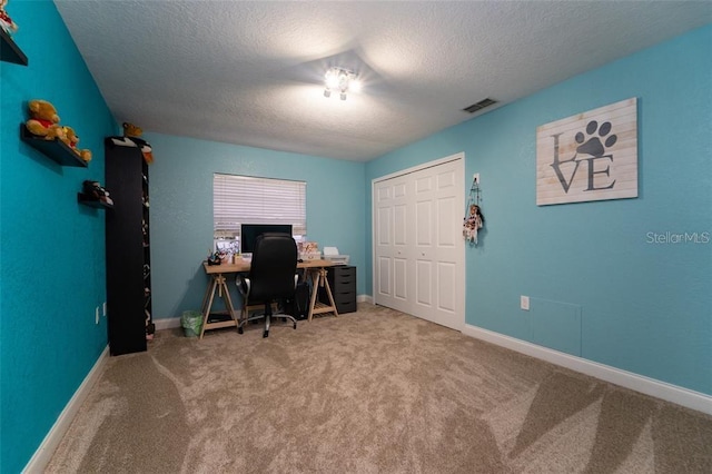 office space with a textured ceiling and light colored carpet