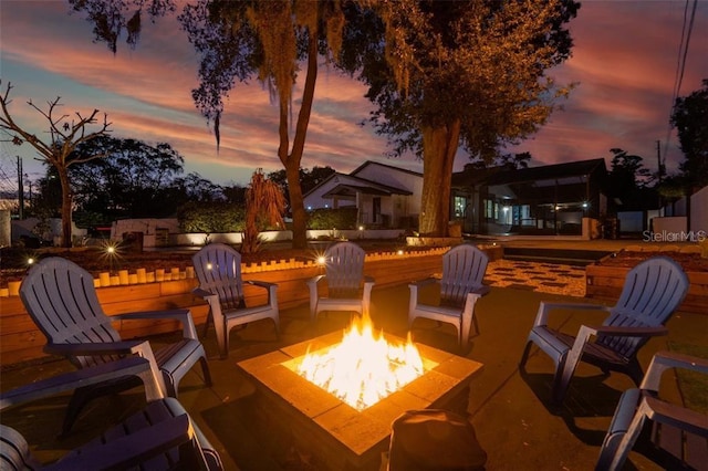 patio terrace at dusk featuring a fire pit