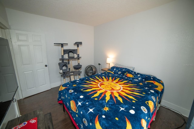 bedroom with a textured ceiling and dark hardwood / wood-style flooring