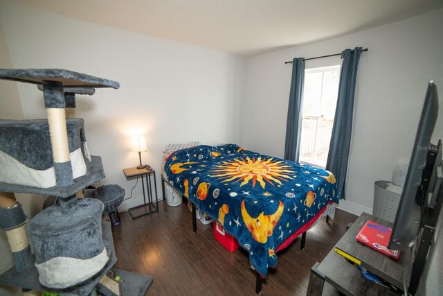 bedroom with dark hardwood / wood-style flooring