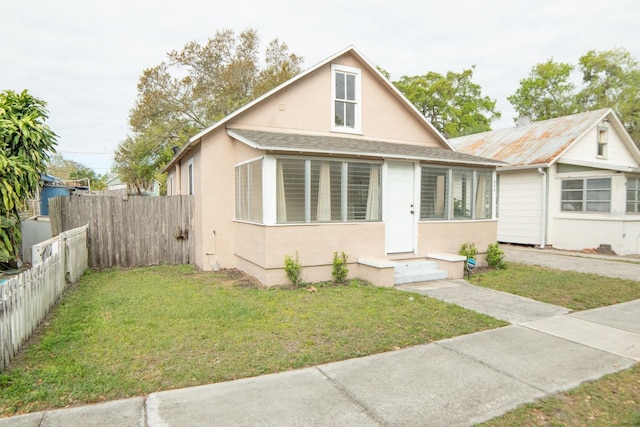 bungalow-style house featuring a front lawn